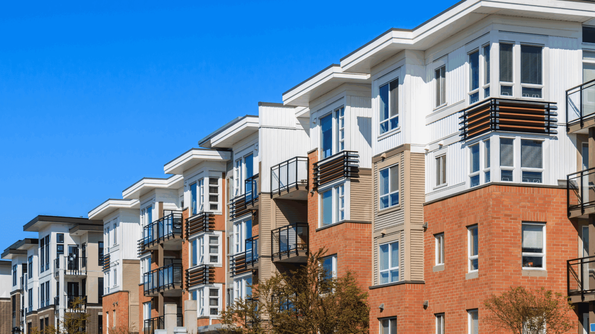 A photo of apartment buildings against a blue sky.