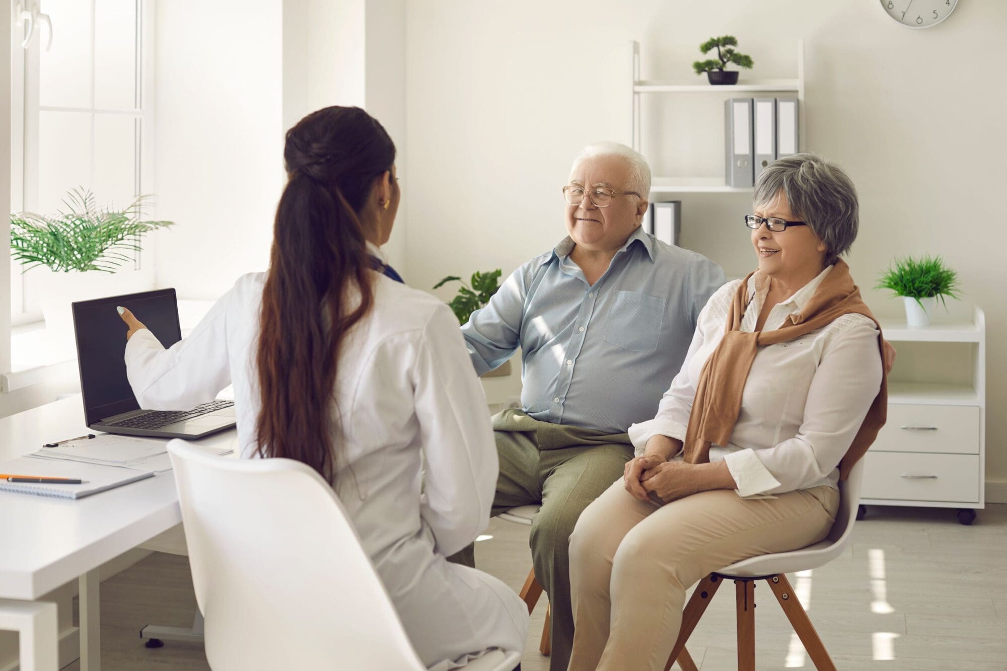 Senior couple reviewing Medicare enrollment documents at a table, making important healthcare decisions.